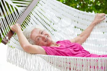 Senior Woman Relaxing In Beach Hammock