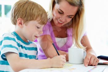 Mother Helping Son With Homework In Kitchen