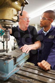 Engineer Teaching Apprentice To Use Milling Machine