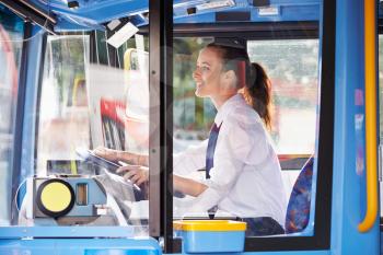 Portrait Of Female Bus Driver Behind Wheel