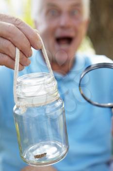 Senior man with cricket in a jar