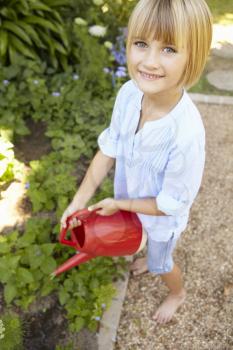 Young girl watering garden