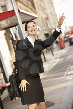Businesswoman hailing bus at stop