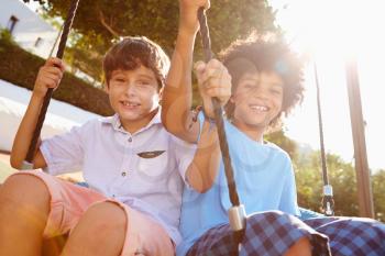 Two Girls Boys Fun On Swing In Playground