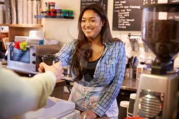 Woman Serving Customer In Coffee Shop