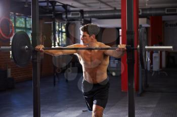 Bare Chested Man In Gym Preparing To Lift Weights