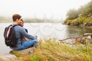 Hiking couple relaxing by the edge of a lake