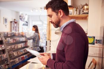 Man working behind the counter at a record shop