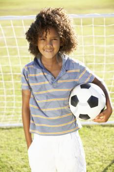 Young Boy With Soccer Ball Standing By Goal