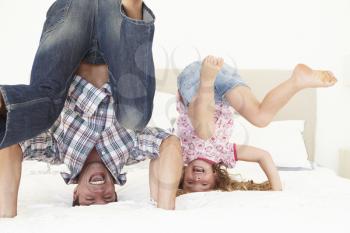 Father And Daughter Playing Together In Bedroom