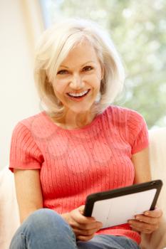 Mid age woman using tablet at home