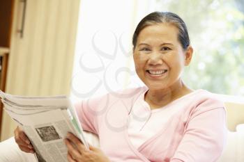 Senior Asian woman reading newspaper
