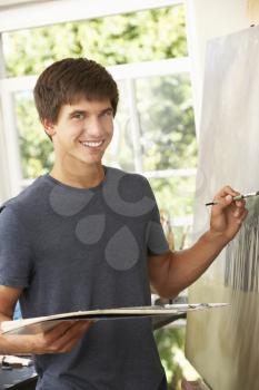 Teenage Boy Working On Painting In Studio