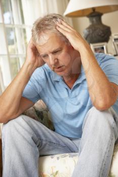 Unhappy Mature Man Sitting On Sofa At Home