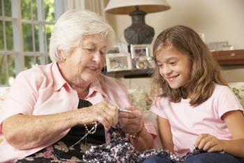 Grandmother Showing Granddaughter How To Knit At Home