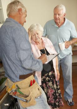 Repairman Giving Senior Couple Estimate For Repair