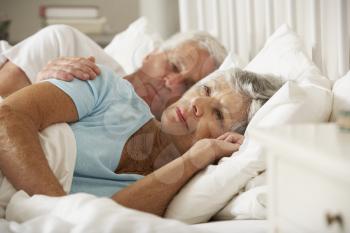 Senior Woman Having Difficulty In Sleeping In Bed With Husband