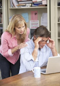 Worried Couple Working In Home Office Together