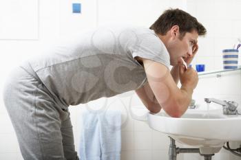 Tired Man In Bathroom Brushing Teeth