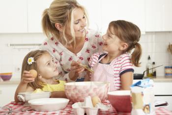 Mother And Two Girls Baking In Kitchen