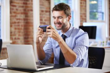 Businessman Using Mobile Phone In Creative Office