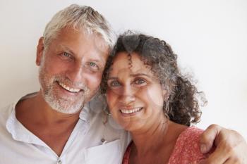 Portrait Of Loving Mature Couple Standing Against Wall