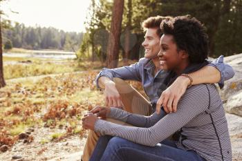 Happy mixed race couple relaxing in the countryside