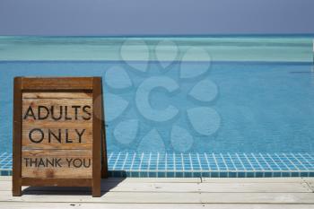 Adults only sign by an infinity pool with ocean beyond