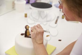 Close Up Of Woman In Bakery Making Monkey Cake Decoration
