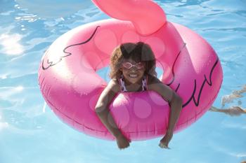Girl Having Fun With Inflatable In Outdoor Swimming Pool