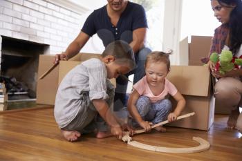 Family Unpacking Boxes In New Home On Moving Day