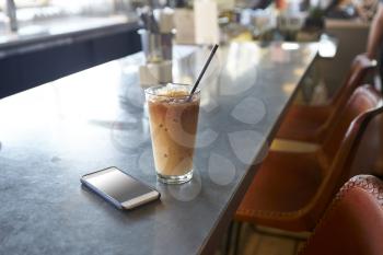Mobile Phone And Cold Press Coffee On Cafe Counter