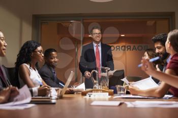 Smiling businessman addressing team at meeting, low angle