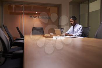 Middle aged black businessman working late alone in office