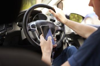 Young Man Sending Text Message Whilst Driving