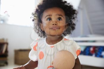 Happy Baby Girl Playing With Doll In Playroom