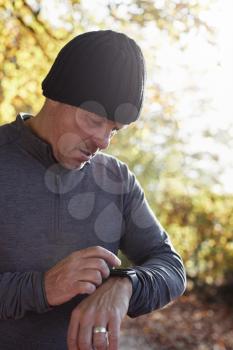 Mature Man On Autumn Run Checking Activity Tracker
