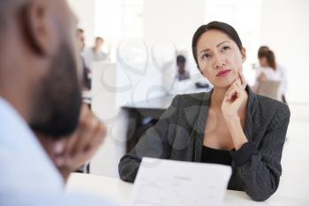 Woman thinking during a job interview in an open plan office
