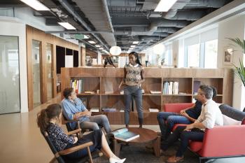 Casually Dressed Businessmen And Businesswomen Having Informal Meeting In Modern Office