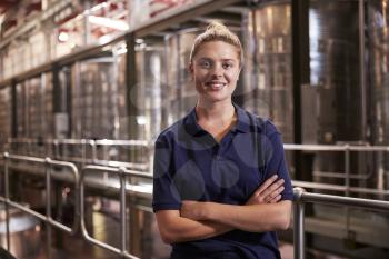 Portrait of a young white woman working at a wine factory