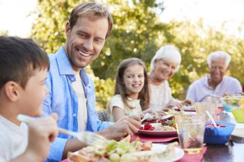 Three generation family having lunch in the garden