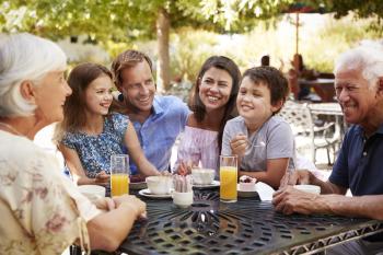 Multi Generation Family Enjoying Snack At Outdoor Caf Together