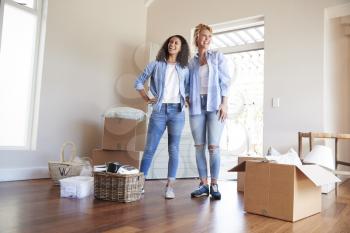 Female Friends Standing In Lounge Of New Home On Moving Day