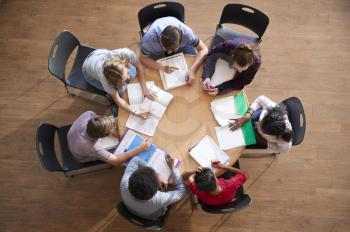 Overhead Shot Of High School Pupils In Group Study Around Tables