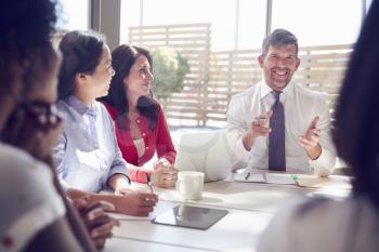 Smiling businessman talking to colleagues in a  meeting room