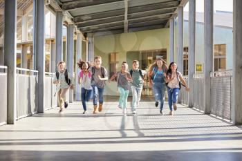 Group of elementary school kids running in a school corridor