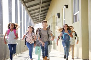 Kids running in elementary school corridor, close up