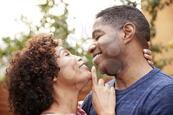 Happy middle aged black couple embracing outdoors, side view,close up
