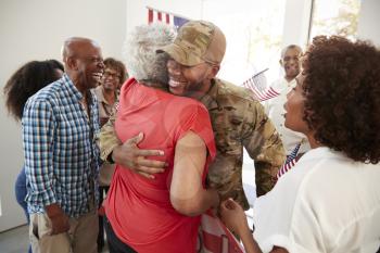 Millennial black soldier returning home to family embracing his grandmother,close up