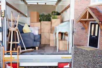 Removal Truck Waiting To Be Unloaded Outside New Home On Moving Day